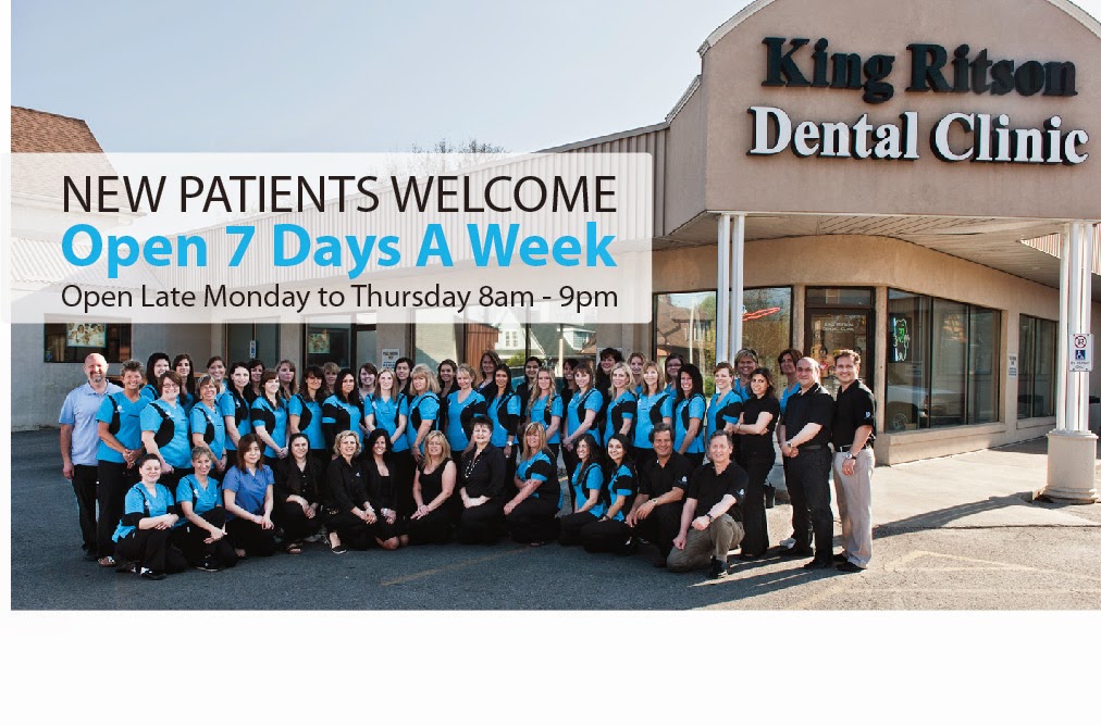 Group photo of dental clinic staff in front of King Ritson Dental Clinic with a banner: New Patients Welcome, Open 7 Days a Week, open late Mon–Thu 8am–9pm.